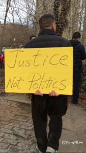 Man holds sign, "Justice Not Politics"