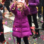 Girl tries to catch confetti on Bayard Street in Chinatown.